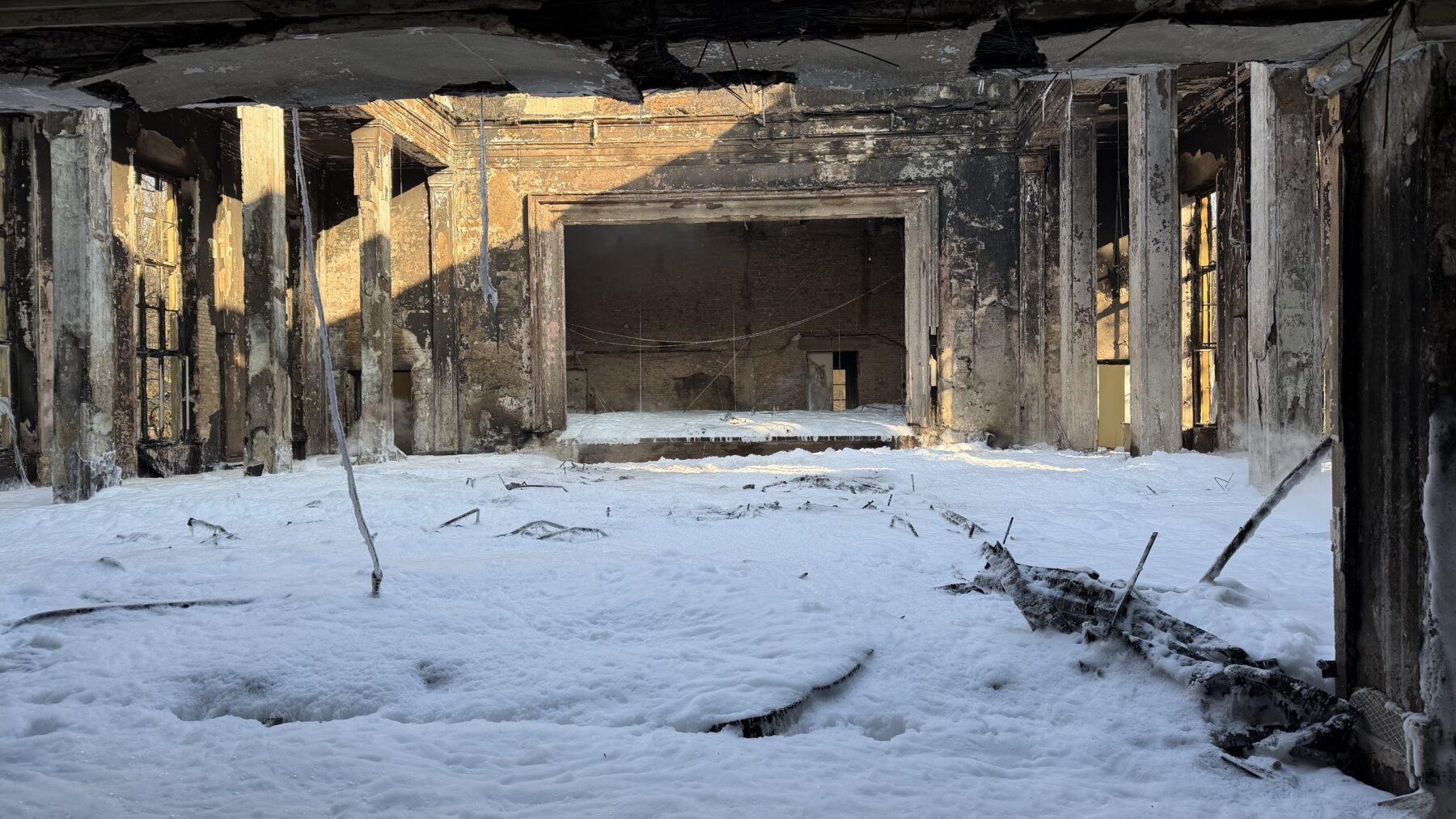 Foto des Innenraums des ausgebrannten Lektionsgebäude mit Löschschaum auf dem Boden.